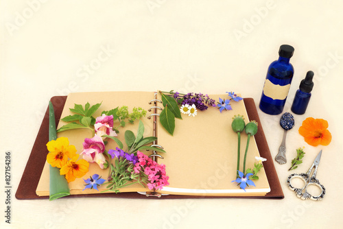 Flowers and herbs for natural aromatherapy treatments. Herbal medicine ingredients for alternative remedies with recipe notebook on hemp paper background.