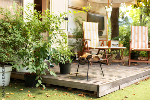 Wallpaper Mural Metal black fireplace bowl with logs in garden. Backyard with RV house with garden furniture and fire steel pit round fireplace appliance for outdoor party. Iron firepit near outside caravan trailer	
 Torontodigital.ca