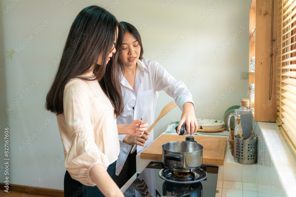 Happy woman friends cooking asian food in kitchen having fun together in home Happy woman friends cooking asian food in kitchen having fun together in home