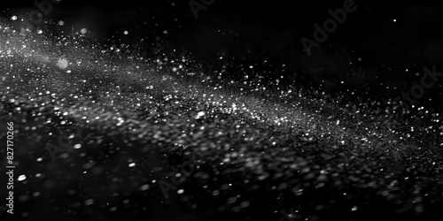 Water spray on black background, white water droplets falling in the air, particles of dust floating in space.Abstract black and white bokeh lights with sparkling particles creating a dramatic