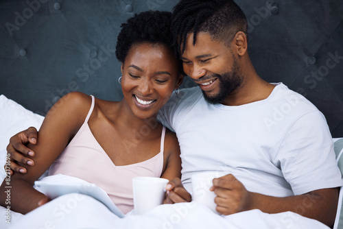 Happy couple, bedroom and tablet with online streaming, website or ecommerce for home shopping or search. African man and woman cuddle together and relax with digital technology and coffee in morning