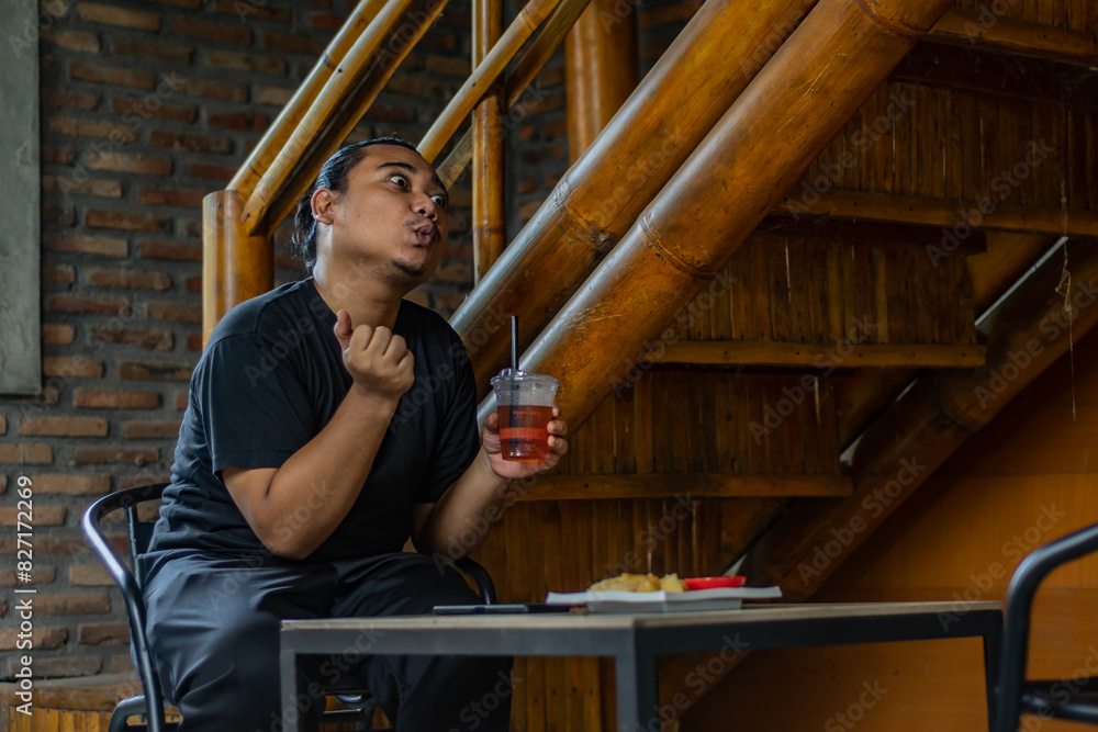 Young Asian man, digital nomad working remotely from cafe, using laptop and smartphone. young Asian men are hanging out in a cafe with an industrial theme Young Asian man, digital nomad working remotely from cafe, using laptop and smartphone. young Asian men are hanging out in a cafe with an industrial theme