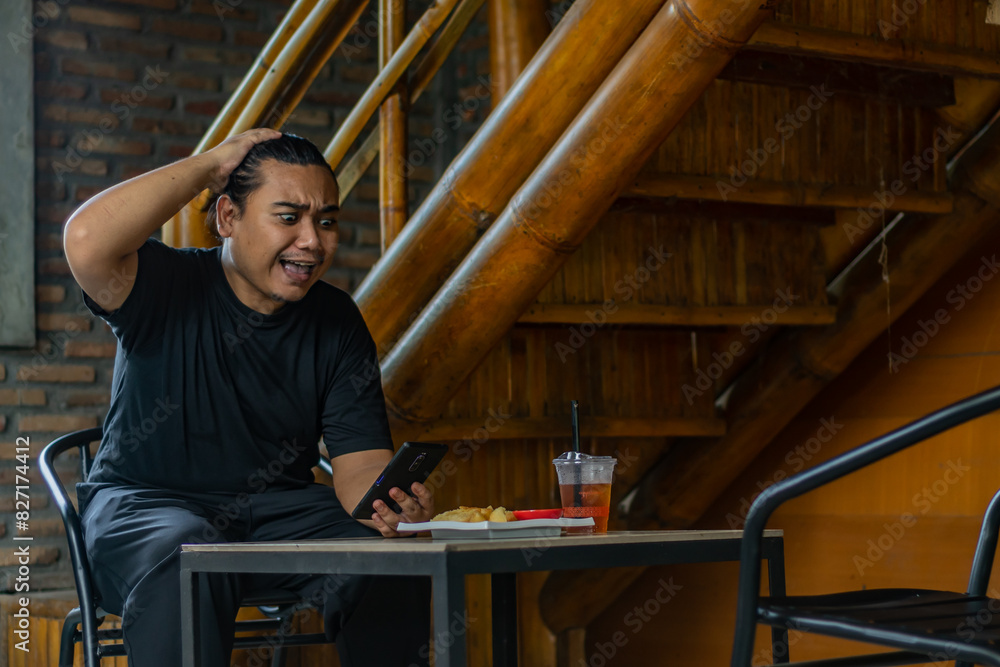 Young asian men, digital nomad working remotely from a cafe, using smartphone. Young asian men, digital nomad working remotely from a cafe, using smartphone.