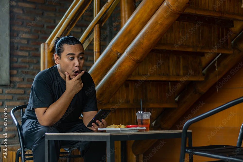 Young asian men, digital nomad working remotely from a cafe, using smartphone. Young asian men, digital nomad working remotely from a cafe, using smartphone.