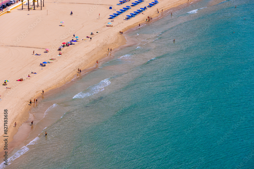 Aerial drone photo of the beautiful town of Benidorm in Spain showing the south beach Promenade golden sandy beach with people on vacation on the beach in the summer time on a hot day.