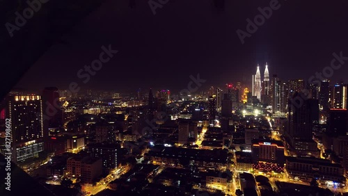 Kuala Lumpur, Malaysia - april 17th, 2024 : panoramic view of Petronas Twin Towers and Kuala Lumpur city skyline buildings midday with sunflare and palm tree. Zoom in wide view