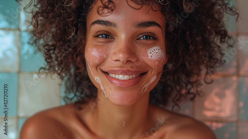 Cheerful woman with curly hair, using moisturizing cream, isolated on a white background photo