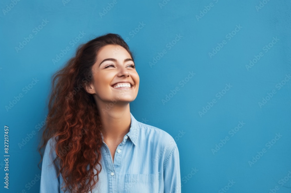 portrait of happy woman next to blue wall portrait of happy woman next to blue wall