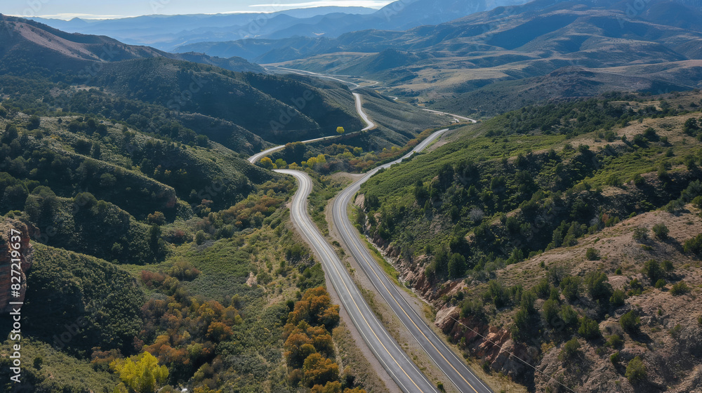 Overhead view showcasing a serpentine road cutting through lush green mountain terrain
