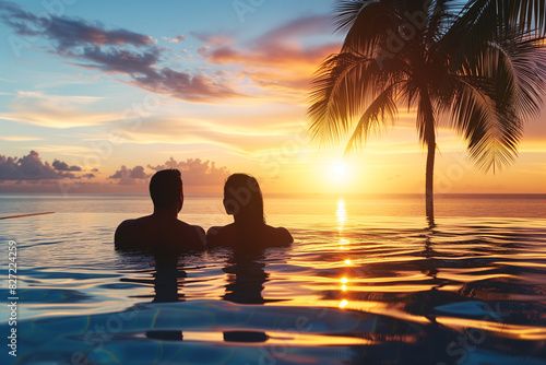 Couple relaxing at tropical beachfront pool in luxury hotel. Summer  holiday and lifestyle concept