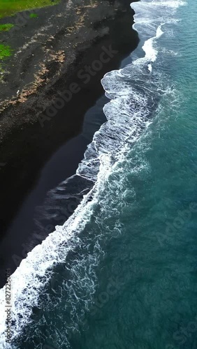 Drone Shot of Black Sand Beach in Indonesia with Mimpang Tepekong in the backround. Aerial View Top Down and Ocean waves crushing. . High quality 4k footage photo