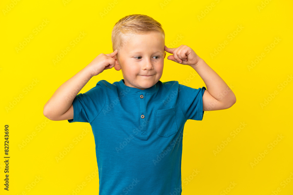 Little Russian boy isolated on yellow background having doubts and thinking Little Russian boy isolated on yellow background having doubts and thinking
