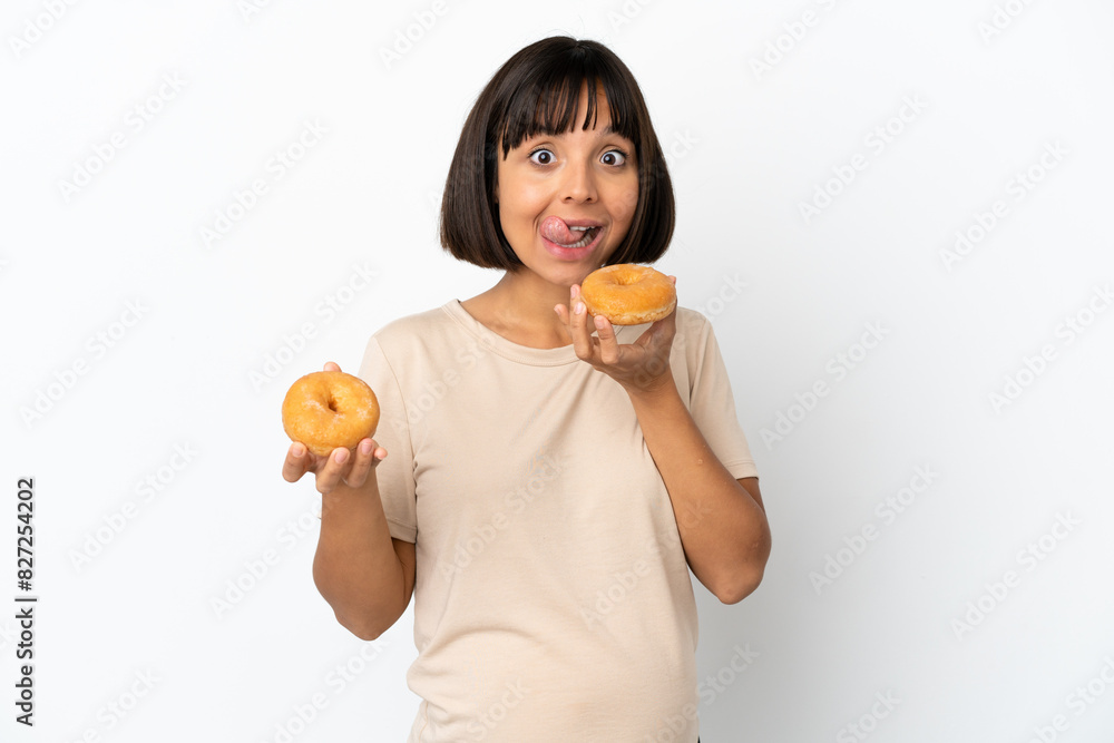 Young mixed race pregnant woman isolated on white background holding a donut Young mixed race pregnant woman isolated on white background holding a donut