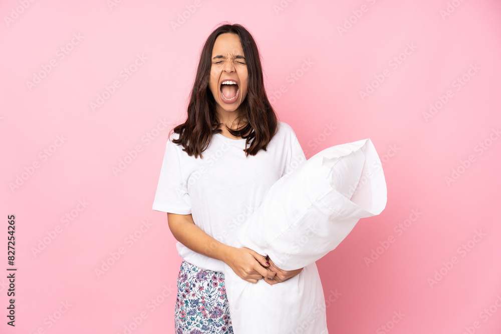 Young woman in pajamas isolated on pink background shouting to the front with mouth wide open Young woman in pajamas isolated on pink background shouting to the front with mouth wide open