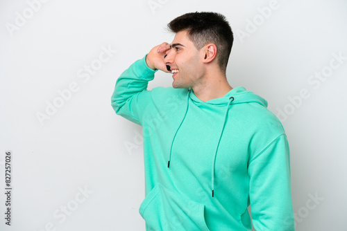 Young caucasian man isolated on white background keeping a conversation with the mobile phone © luismolinero