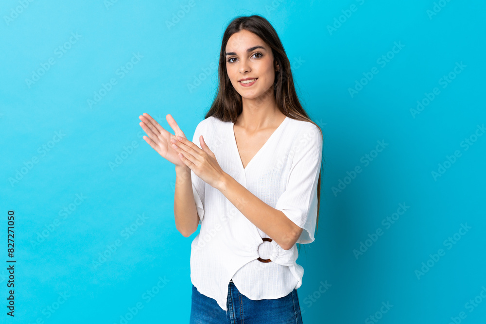Young caucasian woman isolated on blue background applauding after presentation in a conference Young caucasian woman isolated on blue background applauding after presentation in a conference
