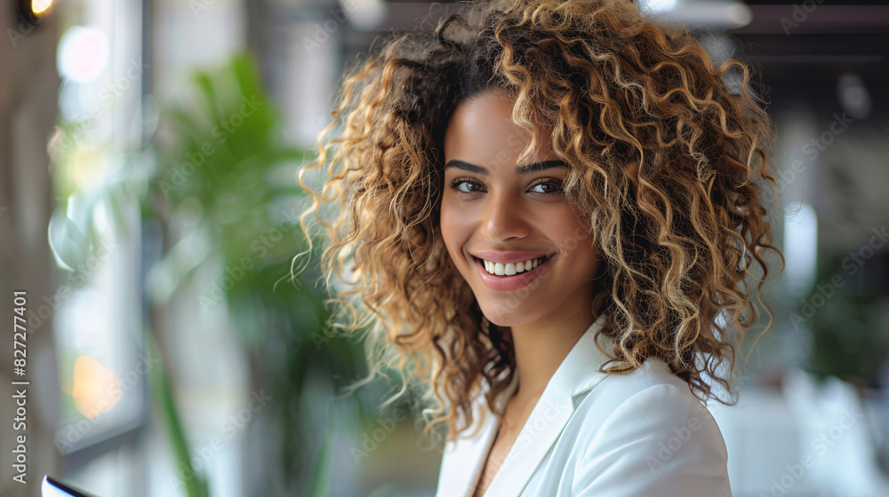 Happy businesswoman with curly hair using a touchpad in a bright office Happy businesswoman with curly hair using a touchpad in a bright office