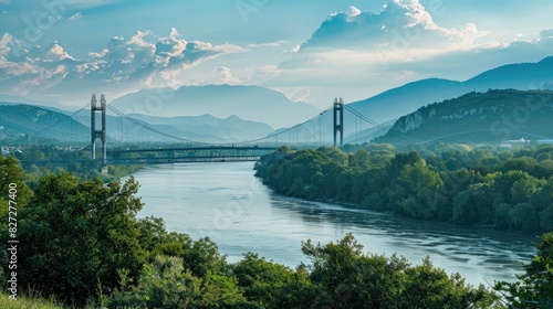 Towering bridge spanning a broad river, viewed from a distance with mountains in the background