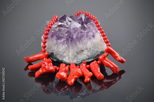 Detail of beautiful red coral necklace on amethyst on black background