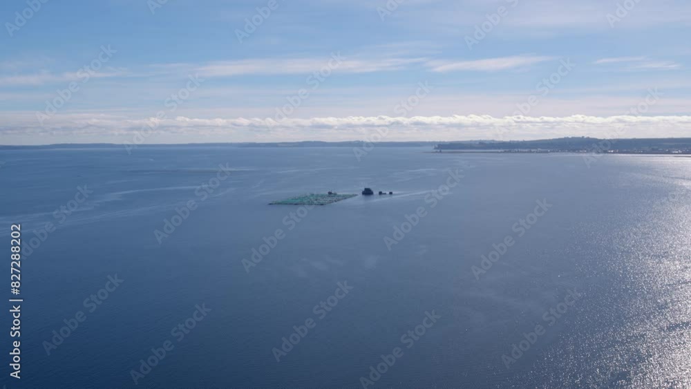 Bird's-eye view of a salmon farming cage in the sea at noon in Chilean Patagonia. Bird's-eye view of a salmon farming cage in the sea at noon in Chilean Patagonia.