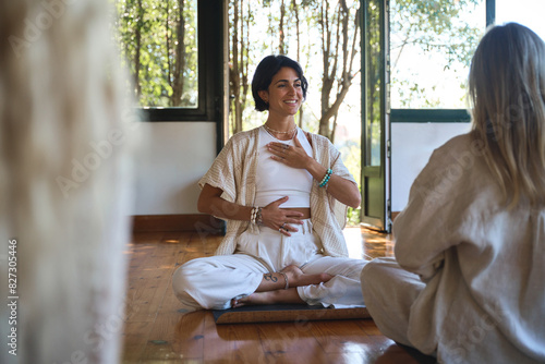 Foto Young happy Hispanic woman yoga coach training group class yoga meditation session sitting in yoga pose practicing breathing pranayama exercises during retreat mind body health holistic therapy