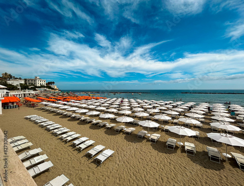 Beach scene with sun loungers and umbrellas of different colors. Civitavecchia, Italy