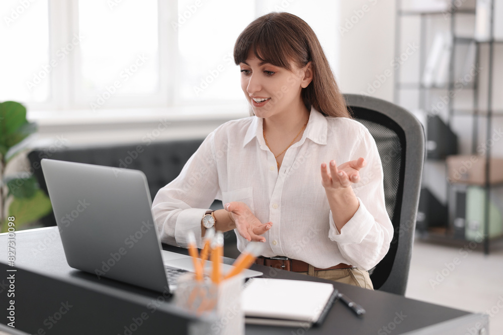 Fototapeta premium Woman using video chat during webinar at table in office