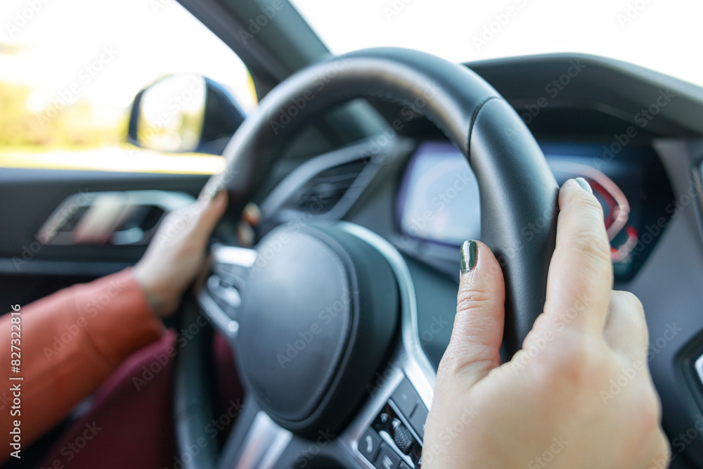Driving a car. Woman hands holding steering wheel