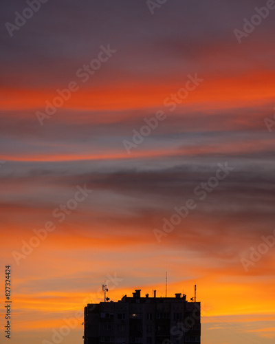 Building silhouetted against a vibrant red evening sky.