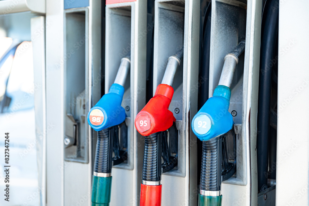 Fuel pistols close up at the gas station. Concept of transportation, energy crisis, oil crisis. Full tank in the midst of a price crisis at the gas pump Fuel pistols close up at the gas station. Concept of transportation, energy crisis, oil crisis. Full tank in the midst of a price crisis at the gas pump