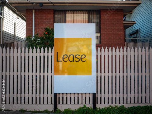 An advertisement sign for a residential property and suburban house listed for lease. Concept of the housing market, real estate, and renting a home.