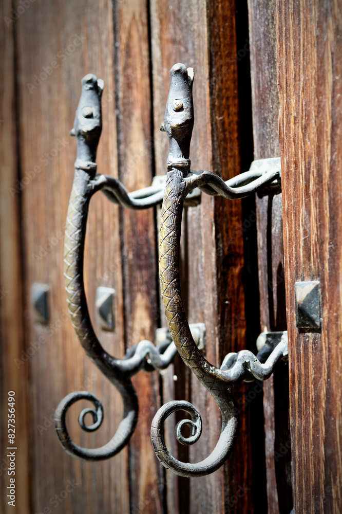 Vertical closeup shot of a wooden door with two metal hooks Vertical closeup shot of a wooden door with two metal hooks