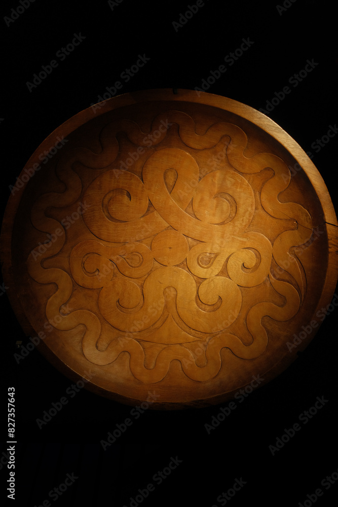 Decorative wooden tray with intricate carvings on a table Decorative wooden tray with intricate carvings on a table