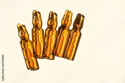 Cosmetic or medical ampoules on a beige background.