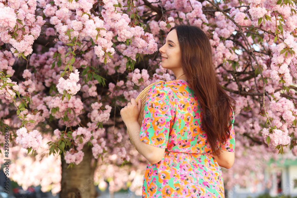 Beautiful woman with straw hat near blossoming tree on spring day Beautiful woman with straw hat near blossoming tree on spring day