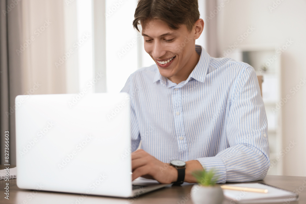 Man watching webinar at table in office Man watching webinar at table in office