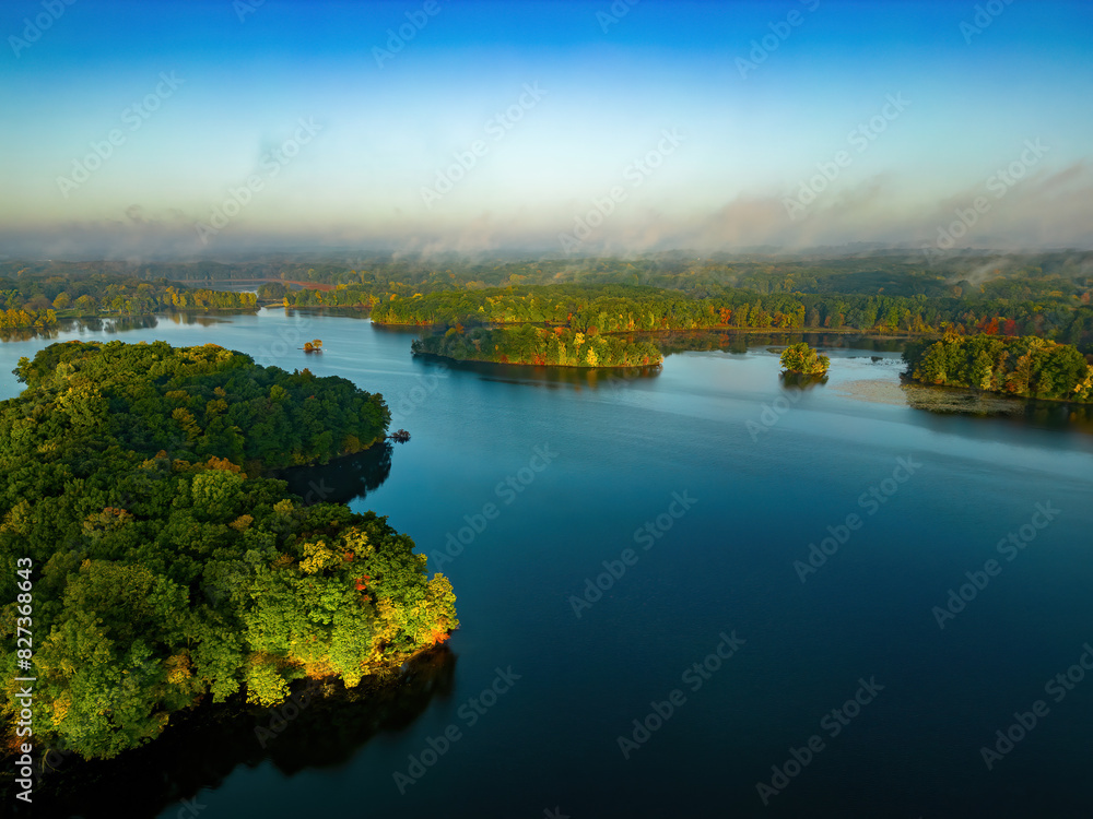 Fototapeta premium Aerial perspective of river and land on a misty day.