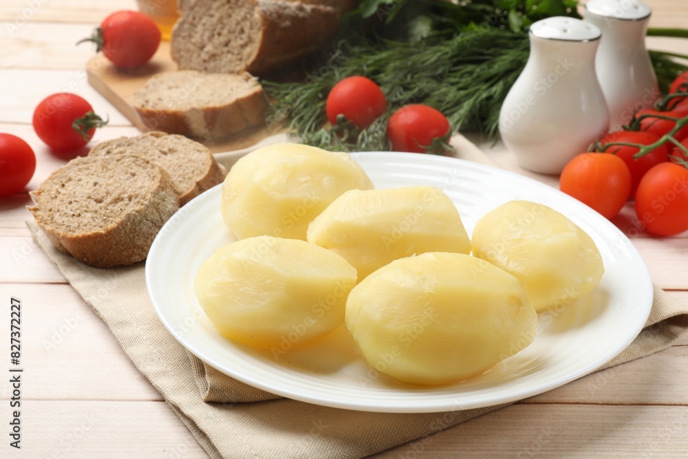Plate with young boiled potatoes on light wooden table, closeup Plate with young boiled potatoes on light wooden table, closeup
