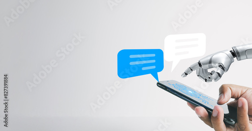 A human hand and a robot hand touching a smartphone screen with a speech bubble icon, idea for  Artificial Intelligence and digital communication,technology, and the future of communication.