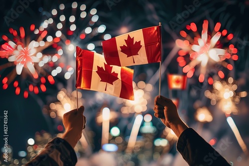 Hands raising Canada flags against festive fireworks at night.