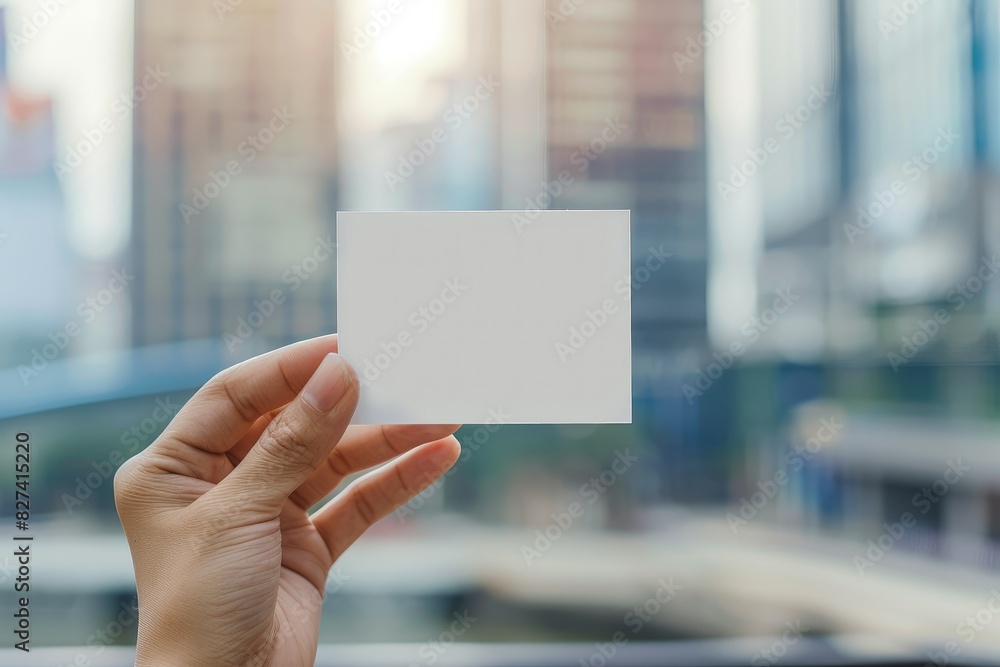 Blank Business card, Paper card template in hand grab on blur outdoor city background. Blank Business card, Paper card template in hand grab on blur outdoor city background.