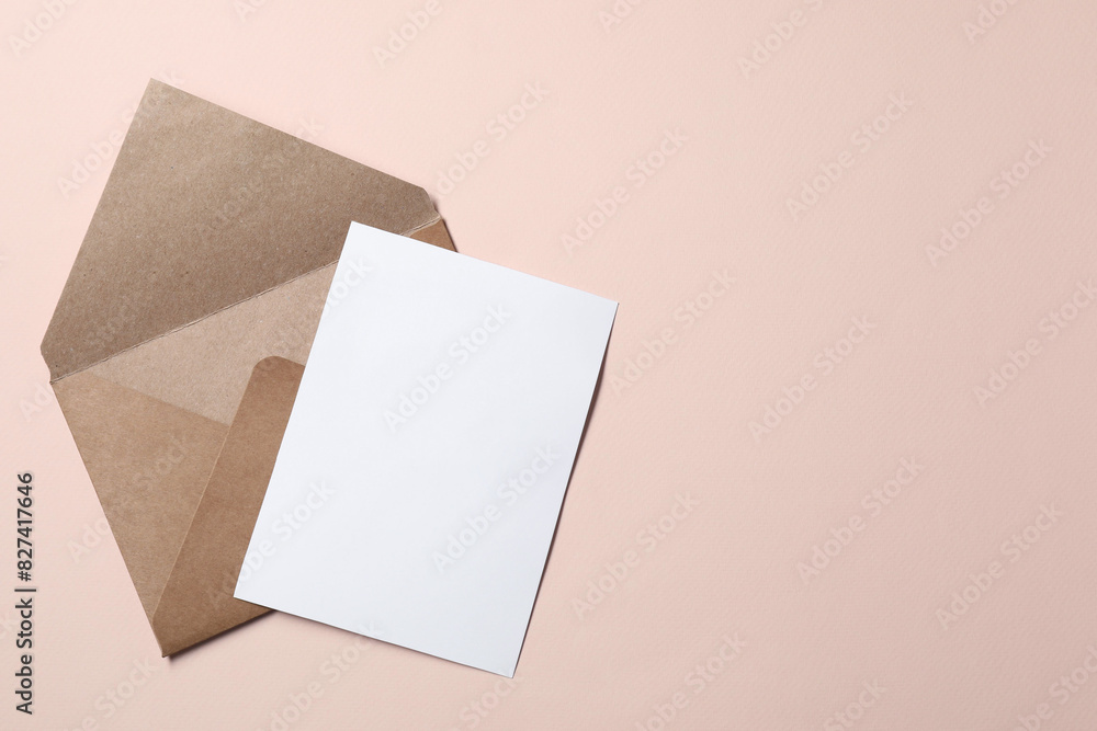 Letter envelope and card on beige background, top view. Space for text Letter envelope and card on beige background, top view. Space for text