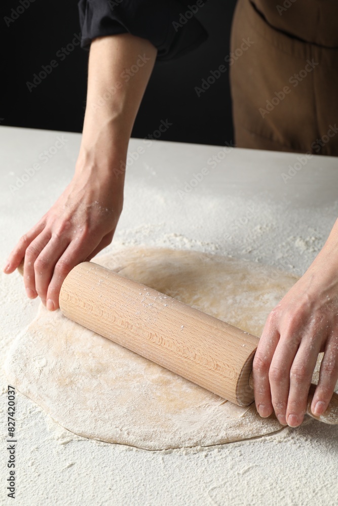 Woman rolling raw dough at table, closeup Woman rolling raw dough at table, closeup