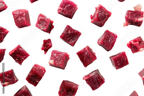 Raw beef meat cubes scattered across a white surface, like dice on a game board, isolated on white background photo