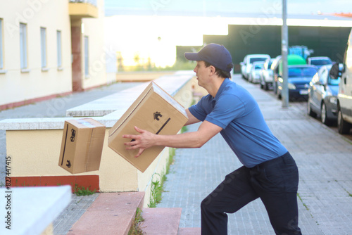 Fotografie Delivery man dropping the order on the street dressed in uniform