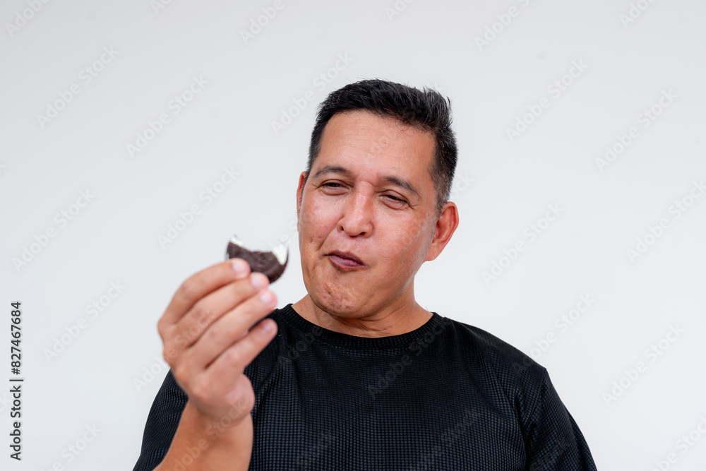 A middle aged man enjoys a nice snack - an extra rich cream filled cookie. A middle aged man enjoys a nice snack - an extra rich cream filled cookie.