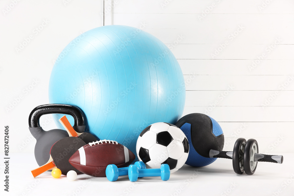 Many different sports equipment on white table Many different sports equipment on white table