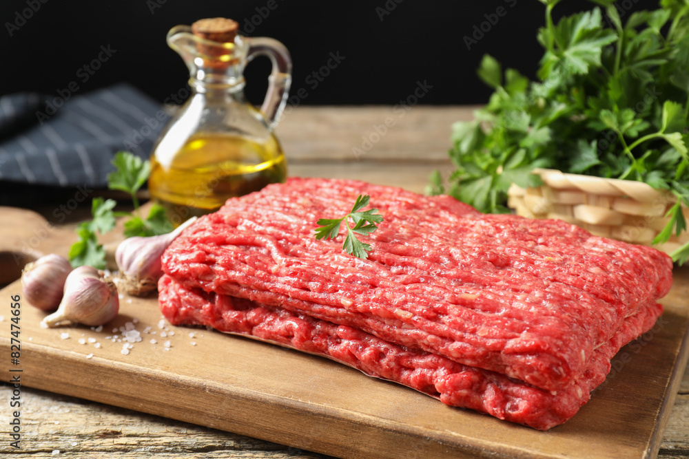 Raw ground meat, garlic, oil and parsley on wooden table Raw ground meat, garlic, oil and parsley on wooden table