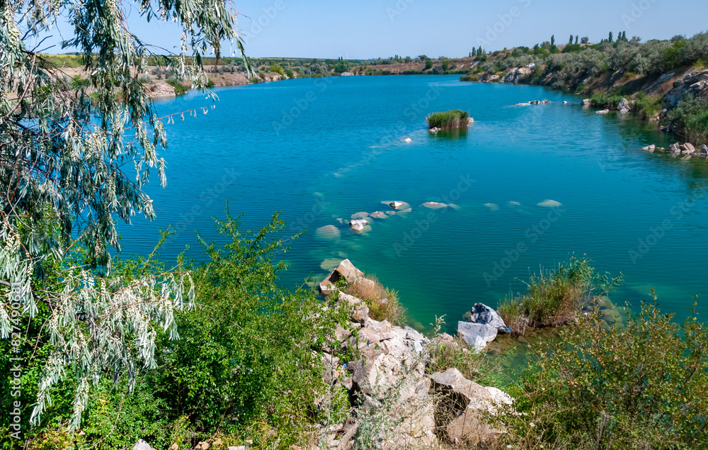 View of the flooded granite quarry with turquoise clear water, Ukraine View of the flooded granite quarry with turquoise clear water, Ukraine
