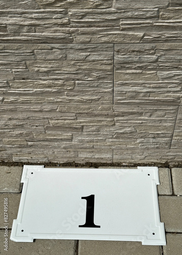 House number plate next to the wall of a building